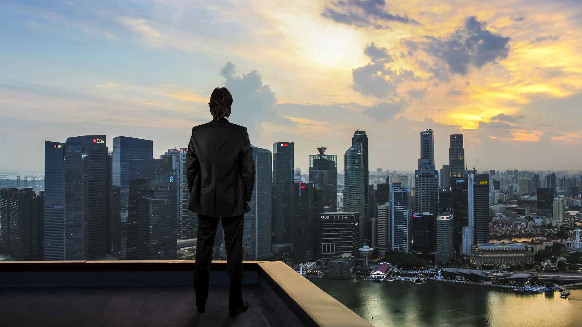 Businessman watching the city on the rooftop of skyscraper